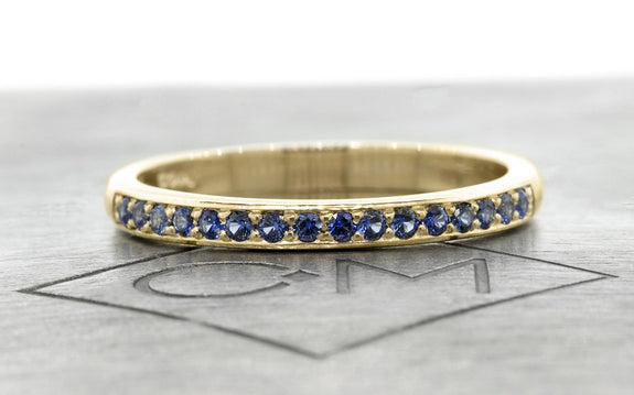 Wedding Band with 16 Blue Sapphires in white gold front view on logo