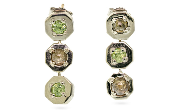 Pair of 14 karat white gold dangle style earring set with demantoid green garnets and cognac diamond cabachons front view on white background